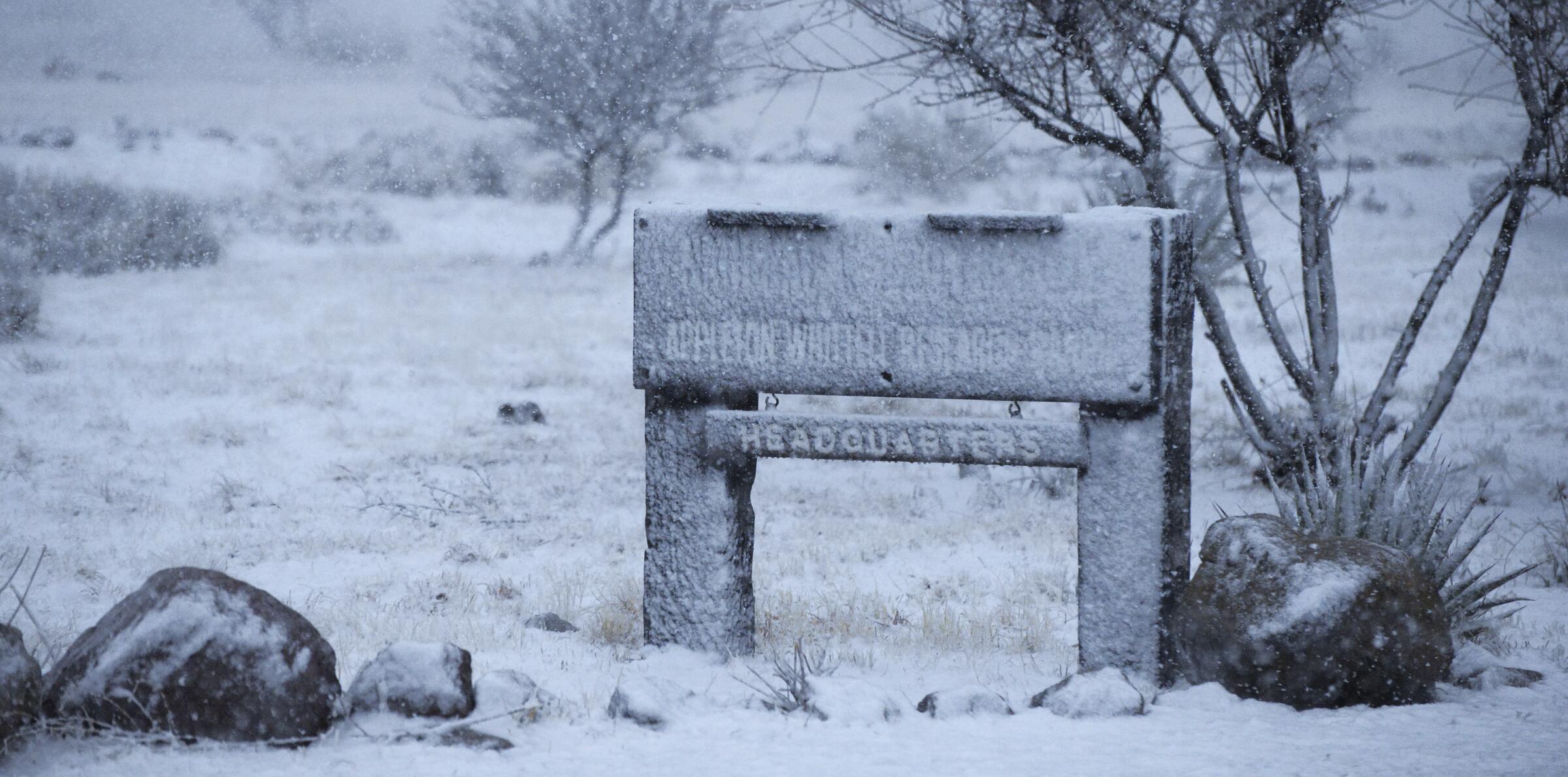 The wooden Appleton-Whittell Research Ranch Headquarters sign covered in snow and ice after an overnight winter storm.